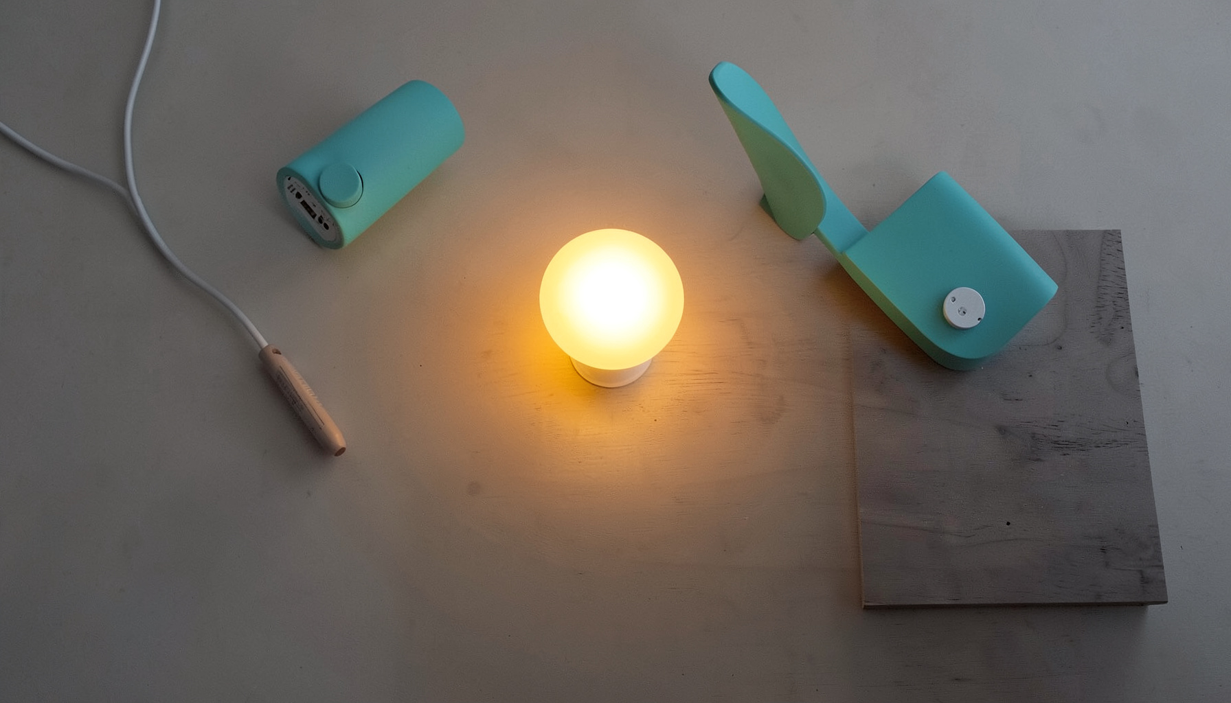 A warm glowing smart LED bulb in a minimalist table lamp on a dark wooden sideboard, casting soft amber light across the surface